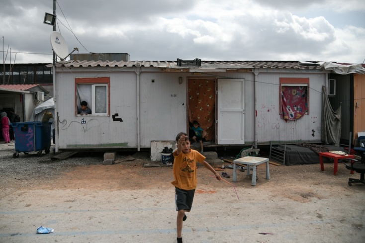 Παιδί μεταναστών σε δομή φιλοξενίας τρέχει έξω από το κατάλυμα