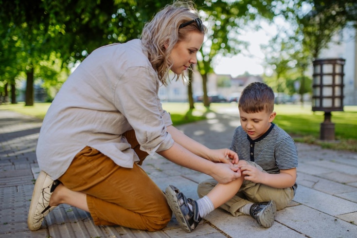 Παιδί που έχει τραυματιστεί και μία κυρία από πάνω του