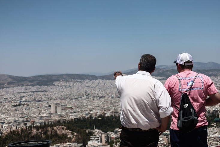 Ακίνητα και δύο άτομα να τα κοιτούν από τον Λυκαβηττό