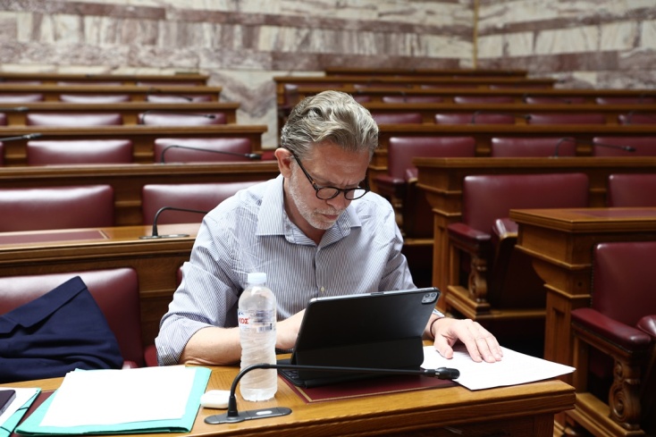 Ο Παύλος Γερουλάνος στα έδρανα της Βουλής γράφει με τον υπολογιστή του