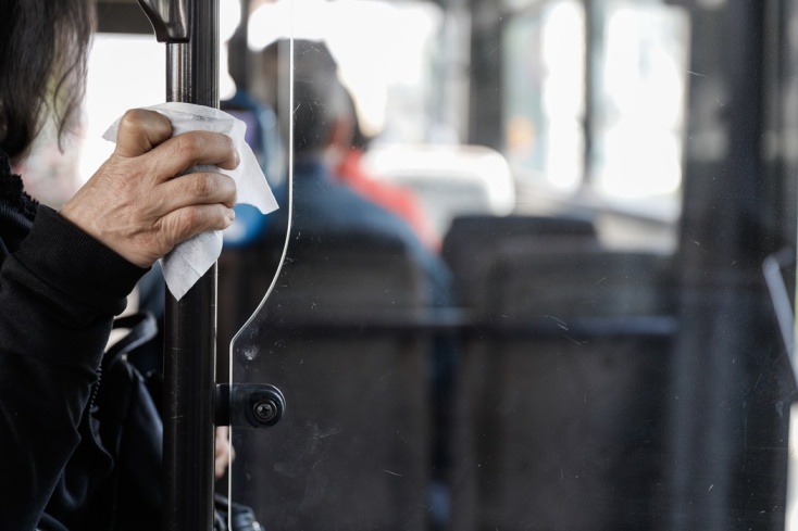 Γυναίκα με χαρτομάντιλο κρατά κάγκελο στο εσωτερικό λεωφορείου