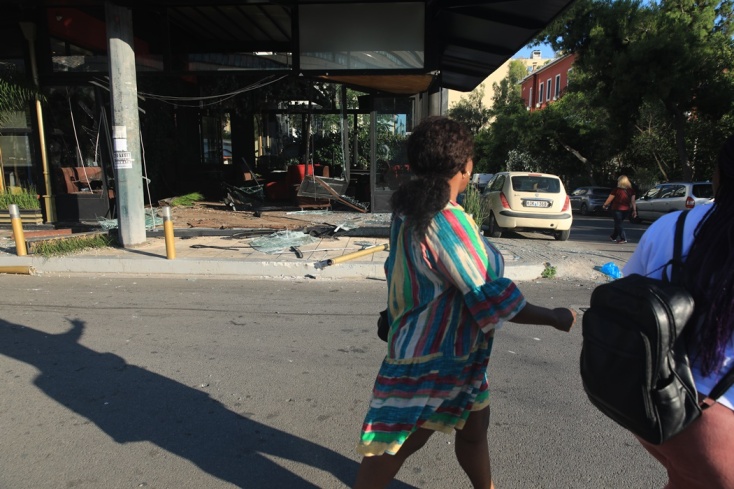 Πολίτες περνούν μπροστά από την καφετέρια όπου έγινε μπήκε το αυτοκίνητο - Ζημιές στον χώρο