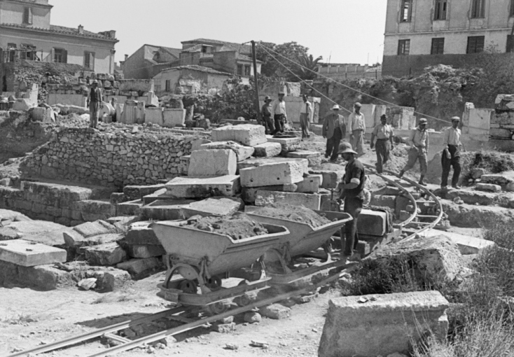Σιδηροδρομικό σύστημα με καρότσια Decauville, 1949. Τα άλογα ήταν το μέσο μεταφοράς χώματος και βαρέων υλικών. Αργότερα, εγκαταστάθηκε ένα σύστημα με ράγες και τα υλικά φορτώνονταν σε καρότσια που προωθούνταν κατά μήκος των ραγών. Η ανασκαφή της Στοάς του Αττάλου αντιμετώπισε σημαντικές προκλήσεις λόγω της εύρεσης 254 επιγραφών, 389 αρχιτεκτονικών μελών και 100 γλυπτών