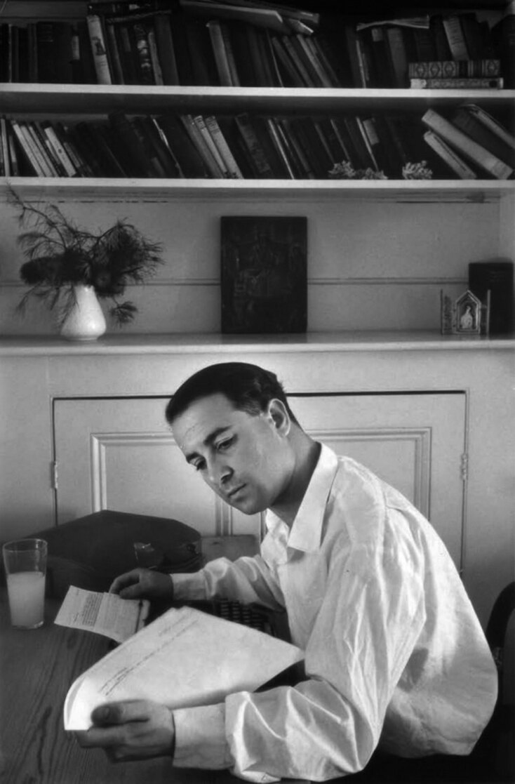 Ο Κώστας Ταχτσής καθώς επεξεργάζεται το δακτυλόγραφό του, υπό το βλέμμα των εικονισμάτων του, οδός Αλεξάντερ, Πάντινγκτον, περ. 1959. © Ντέιβιντ Μουρ