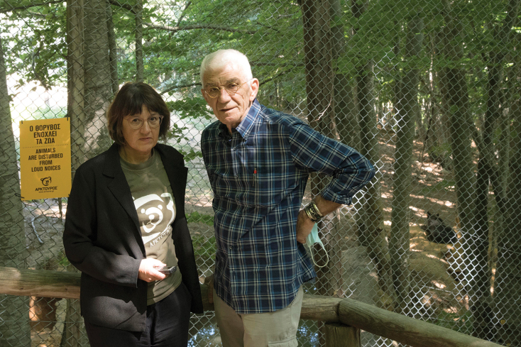 Ο Γιάννης Μπουτάρης στο καταφύγιο άγριων ζώων του Αρκτούρου στο Νυμφαίο με τη συγγραφέα Μαρία Μαυρικάκη. Πίσω τους διακρίνεται η Βαρβάρα, η αρκούδα που είναι υιοθετημένη από τον Πατριάρχη. ©Βαγγέλης Τσιάμης