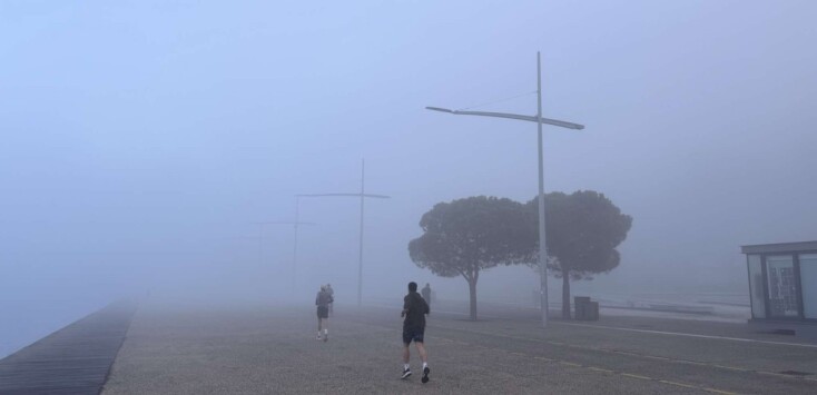 Πολίτες περπατούν στην παραλία της Θεσσαλονίκης, όπου η ορατότητα είναι περιορισμένη