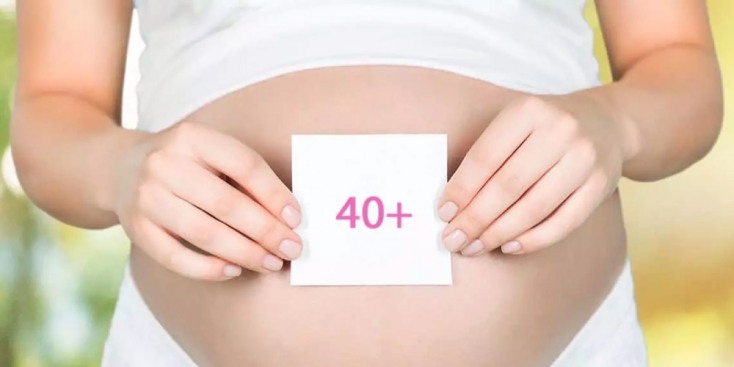 Έγκυος γυναίκα κρατάει χαρτί που γράφει 40+