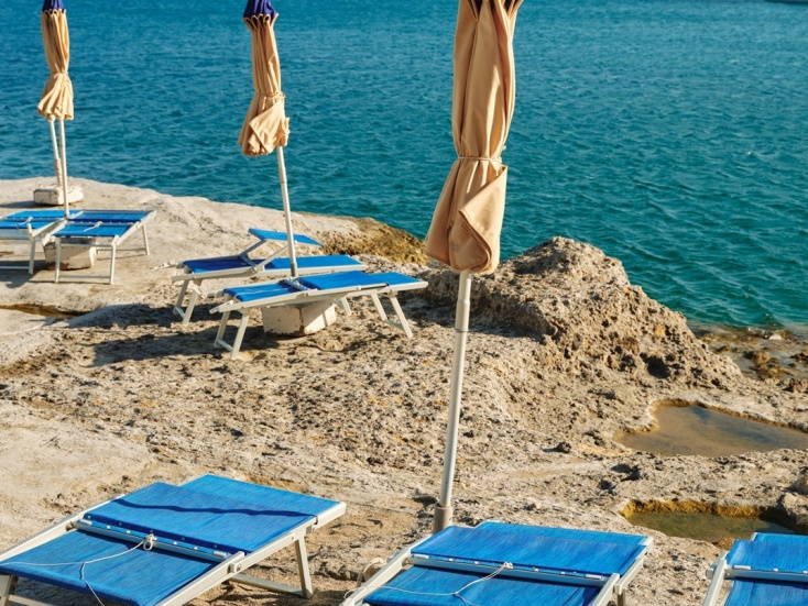 Ξαπλώστρες δίπλα σε παραλία