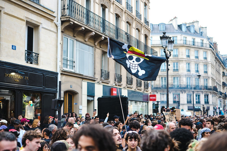 Σημαία με το logo του One Piece σε πορεία διαμαρτυρίας του κινήματος "Bloquons tout" 