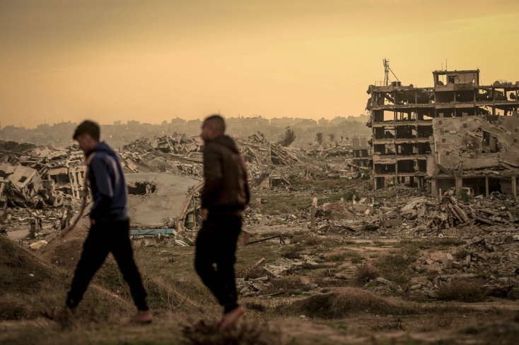 Πολίτες περπατούν ανάμεσα σε ερείπια στη Γάζα