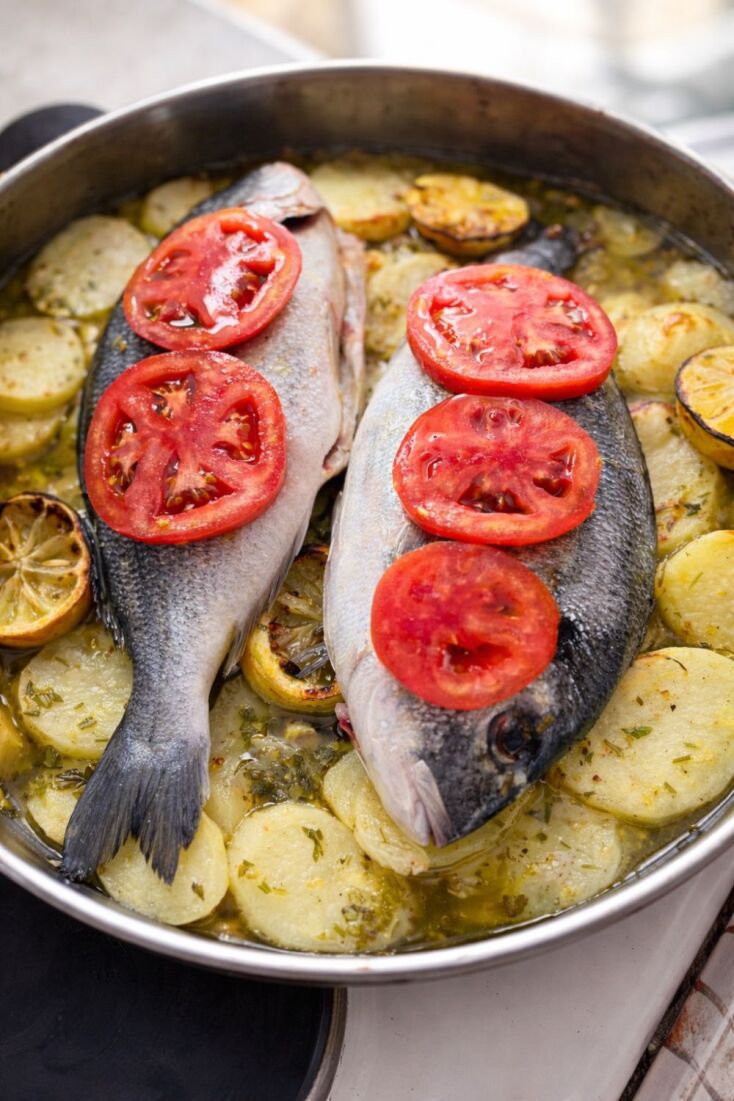 Τσιπούρα στον φούρνο με πατάτες, κρεμμύδια, λεμόνια και ντομάτα