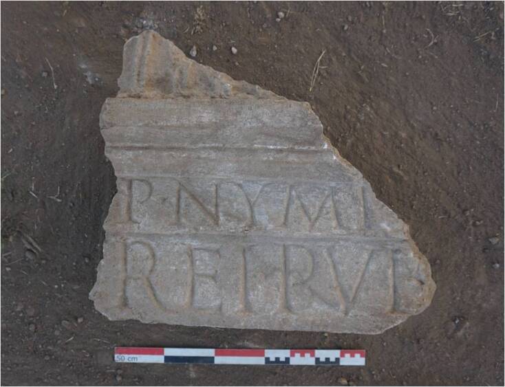 Η δεύτερη επιγραφή σώζεται σε δυο σειρές, σε λατινική γραφή και κεφαλαία γράμματα: στην πρώτη σειρά σώζεται το εξής P·NYMP και στη δεύτερη σειρά REI·PVB