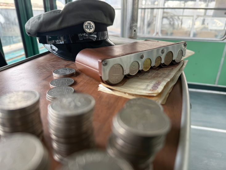 Κερματοθήκη με δραχμές και παλιό πηλίκιο ΕΚΤΕΛ στο γραφειάκι του εισπράκτορα