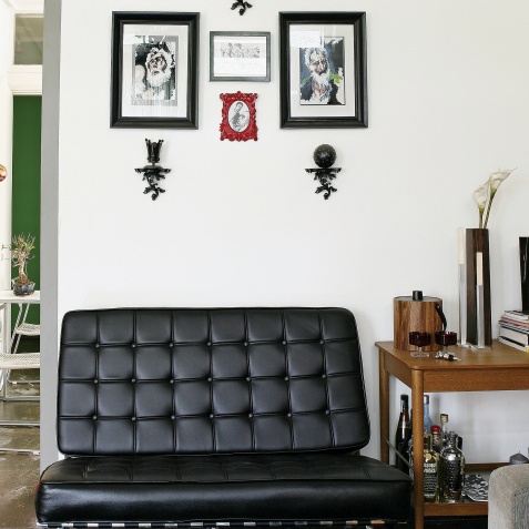 Το καθιστικό δίπλα στην κουζίνα, με την πολυθρόνα Barcelona στο αγαπημένο του μαύρο χρώμα και τα coffee table books σε πρώτη ζήτηση Στο σπίτι ενός λάτρη των Σούπερ Ηρώων