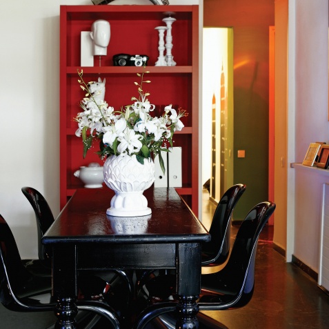 Η mix & match τραπεζαρία με το παλιό ξύλινο τραπέζι της μαμάς του ιδιοκτήτη βαμμένο σε μαύρο χρώμα, για να ταιριάζει με τις καρέκλες Verner Panton και την αγαπημένη του αστραφτερή disco-μπάλα φωτιστικό Στο σπίτι ενός λάτρη των Σούπερ Ηρώων