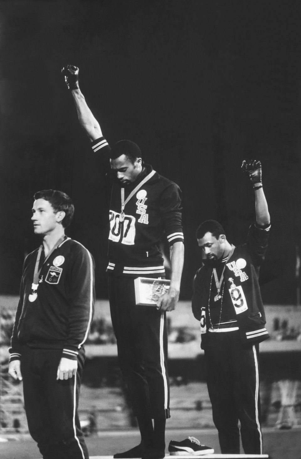 John Dominis (American, 1921–2013). American track and field athletes Tommie Smith (C) and John Carlos (R), first and third place winners in the 200 meter race, protest with the Black Power salute as they stand on the winner's podium at the Summer Olympic games, Mexico City, Mexico, October 19, 1968. Australian silver medalist Peter Norman stands by, 1968; printed 2016. Inkjet print, 14 x 9¼ in. (35.6 x 23.3 cm). Courtesy of John Dominis/Getty Image John Dominis (American, 1921–2013). American track and field athletes Tommie Smi