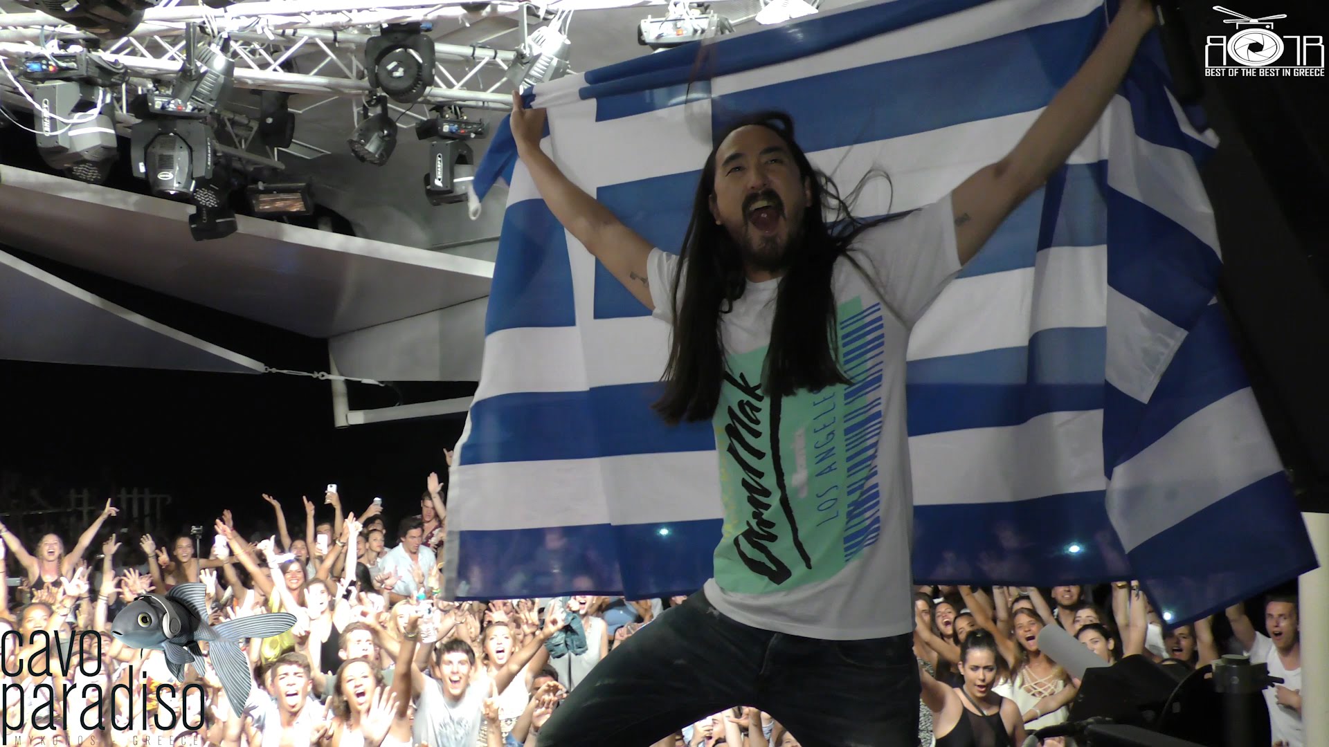 Ο dj Steve Aoki, με τρελό ενθουσιασμό, ανεμίζει την ελληνική σημαία στο Cavo Paradiso της Μυκόνου.