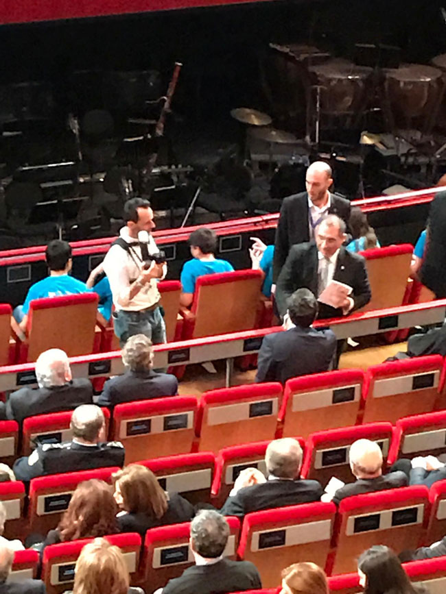  Προσέρχεται ο Αλέξης Τσίπρας, δεν αναγνωρίζει τον Φίλιππο Νιάρχο, τον προσπερνά και κάθεται μια θέση παραδίπλα. Στο τέλος αναλαμβάνει τις συστάσεις ο Νίκος Βούτσης.