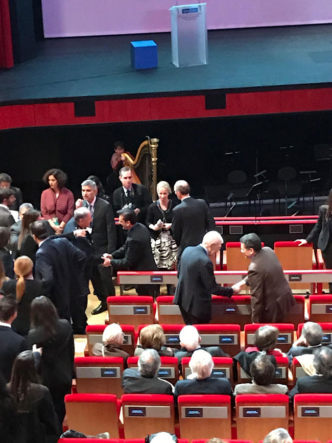  Προσέρχεται ο Αλέξης Τσίπρας, δεν αναγνωρίζει τον Φίλιππο Νιάρχο, τον προσπερνά και κάθεται μια θέση παραδίπλα. Στο τέλος αναλαμβάνει τις συστάσεις ο Νίκος Βούτσης.