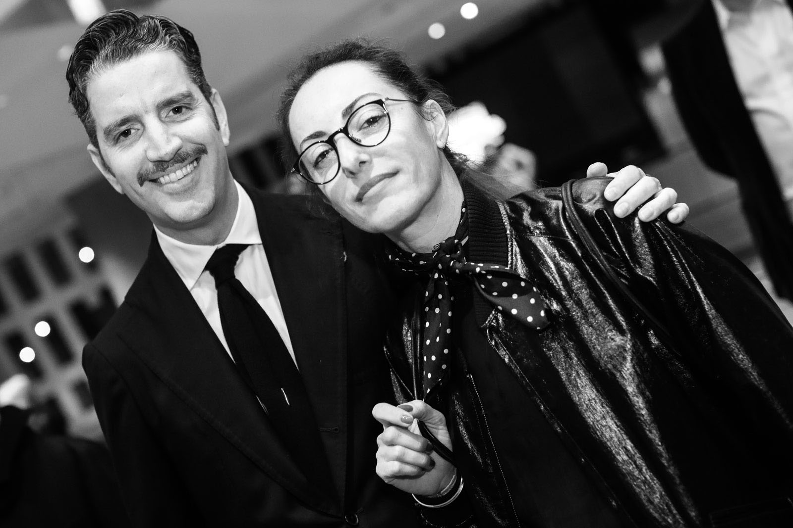 Ο Κίμων Φραγκάκης με άψογο bespoke σακάκι και ανάλογο μουστάκι αγκαλιά με τη φωτογράφο Μάρα Δεσύπρη