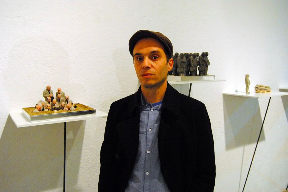 O Isaac Cordal, γεννημένος το 1974, είναι Ισπανός καλλιτέχνης από τη Γαλικία και ζει στις Βρυξέλλες. Τα έργα του συνδυάζουν τη μικρογλυπτική με τη φωτογραφία μέσα στο αστικό τοπίο. Έχει σπουδάσει γλυπτική, έχει ειδικευτεί στην τεχνική της πέτρας και υπήρξε μέλος καλλιτεχνικών ομάδων, γκρουπ της death metal μουσικής σκηνής της Ισπανίας καθώς και εκδότης του fanzine Exorcism. Αυτό που κάνει ο Ισπανός καλλιτέχνης είναι κάτι περισσότερο από urban art. Θα έλεγε κανείς ότι είναι ένα παιχνίδι «κρυμμένου θησαυρού», η δημιουργία ενός μικρόκοσμου μέσα στην πόλη και στις μυστικές γωνιές της. Δημιουργεί μικρές ανθρώπινες φιγούρες (περίπου 15 εκ. ύψος) από πηλό, κατασκευάζει καλούπια και μετά τις μετατρέπει σε φιγούρες από τσιμέντο, συνήθως ανθρώπους businessmen με καφκική διάθεση, που τους στήνει σε πόζες, μόνους ή όλους μαζί στο σύμπαν της πόλης, σατιρίζοντας σκληρά τον σύγχρονο κόσμο, την κλιματική αλλαγή, τη γραφειοκρατία, τη μοναξιά. Συνήθως είναι δύσκολο να τα ανακαλύψεις με την πρώτη ματιά, πρέπει να ψάξεις ιδιαίτ O Isaac Cordal, γεννημένος το 1974, είναι Ισπανός καλλιτέχνης από τη Γαλικία και ζει στις Βρυξέλλες. Τα έργα του συνδυάζουν τη μικρογλυπτική με τη φωτογραφία μέσα στο αστικό τοπίο. Έχει σπουδάσει γλυπτική, έχει ειδικευτεί στην τεχνική της πέτρας και υπήρξε μέλος καλλιτεχνικών ομάδων, γκρουπ της death metal μουσικής σκηνής της Ισπανίας καθώς και εκδότης του fanzine Exorcism. Αυτό που κάνει ο Ισπανός καλλιτέχνης είναι κάτι περισσότερο από urban art. Θα έλεγε κανείς ότι είναι ένα παιχνίδι «κρυμμένου θησαυρού»