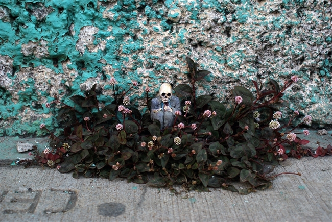 O Isaac Cordal, γεννημένος το 1974, είναι Ισπανός καλλιτέχνης από τη Γαλικία και ζει στις Βρυξέλλες. Τα έργα του συνδυάζουν τη μικρογλυπτική με τη φωτογραφία μέσα στο αστικό τοπίο. Έχει σπουδάσει γλυπτική, έχει ειδικευτεί στην τεχνική της πέτρας και υπήρξε μέλος καλλιτεχνικών ομάδων, γκρουπ της death metal μουσικής σκηνής της Ισπανίας καθώς και εκδότης του fanzine Exorcism. Αυτό που κάνει ο Ισπανός καλλιτέχνης είναι κάτι περισσότερο από urban art. Θα έλεγε κανείς ότι είναι ένα παιχνίδι «κρυμμένου θησαυρού», η δημιουργία ενός μικρόκοσμου μέσα στην πόλη και στις μυστικές γωνιές της. Δημιουργεί μικρές ανθρώπινες φιγούρες (περίπου 15 εκ. ύψος) από πηλό, κατασκευάζει καλούπια και μετά τις μετατρέπει σε φιγούρες από τσιμέντο, συνήθως ανθρώπους businessmen με καφκική διάθεση, που τους στήνει σε πόζες, μόνους ή όλους μαζί στο σύμπαν της πόλης, σατιρίζοντας σκληρά τον σύγχρονο κόσμο, την κλιματική αλλαγή, τη γραφειοκρατία, τη μοναξιά. Συνήθως είναι δύσκολο να τα ανακαλύψεις με την πρώτη ματιά, πρέπει να ψάξεις ιδιαίτ O Isaac Cordal, γεννημένος το 1974, είναι Ισπανός καλλιτέχνης από τη Γαλικία και ζει στις Βρυξέλλες. Τα έργα του συνδυάζουν τη μικρογλυπτική με τη φωτογραφία μέσα στο αστικό τοπίο. Έχει σπουδάσει γλυπτική, έχει ειδικευτεί στην τεχνική της πέτρας και υπήρξε μέλος καλλιτεχνικών ομάδων, γκρουπ της death metal μουσικής σκηνής της Ισπανίας καθώς και εκδότης του fanzine Exorcism. Αυτό που κάνει ο Ισπανός καλλιτέχνης είναι κάτι περισσότερο από urban art. Θα έλεγε κανείς ότι είναι ένα παιχνίδι «κρυμμένου θησαυρού»