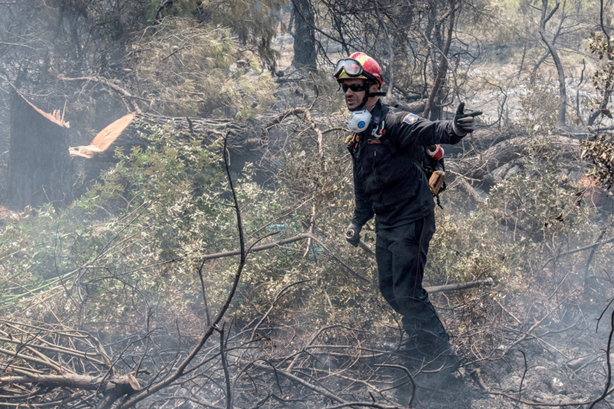 Πυροσβέστης επιχειρεί στην κατάσβεση της πυρκαγιά κοντά στο χωριό Μακρυμάλλη