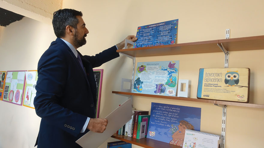 Ο Α. Σιαράβας, Marketing & Communications Manager, KPMG στην Ελλάδα τοποθετεί βιβλία στο 2ο Δημοτικό Σχολείο Ραφήνας