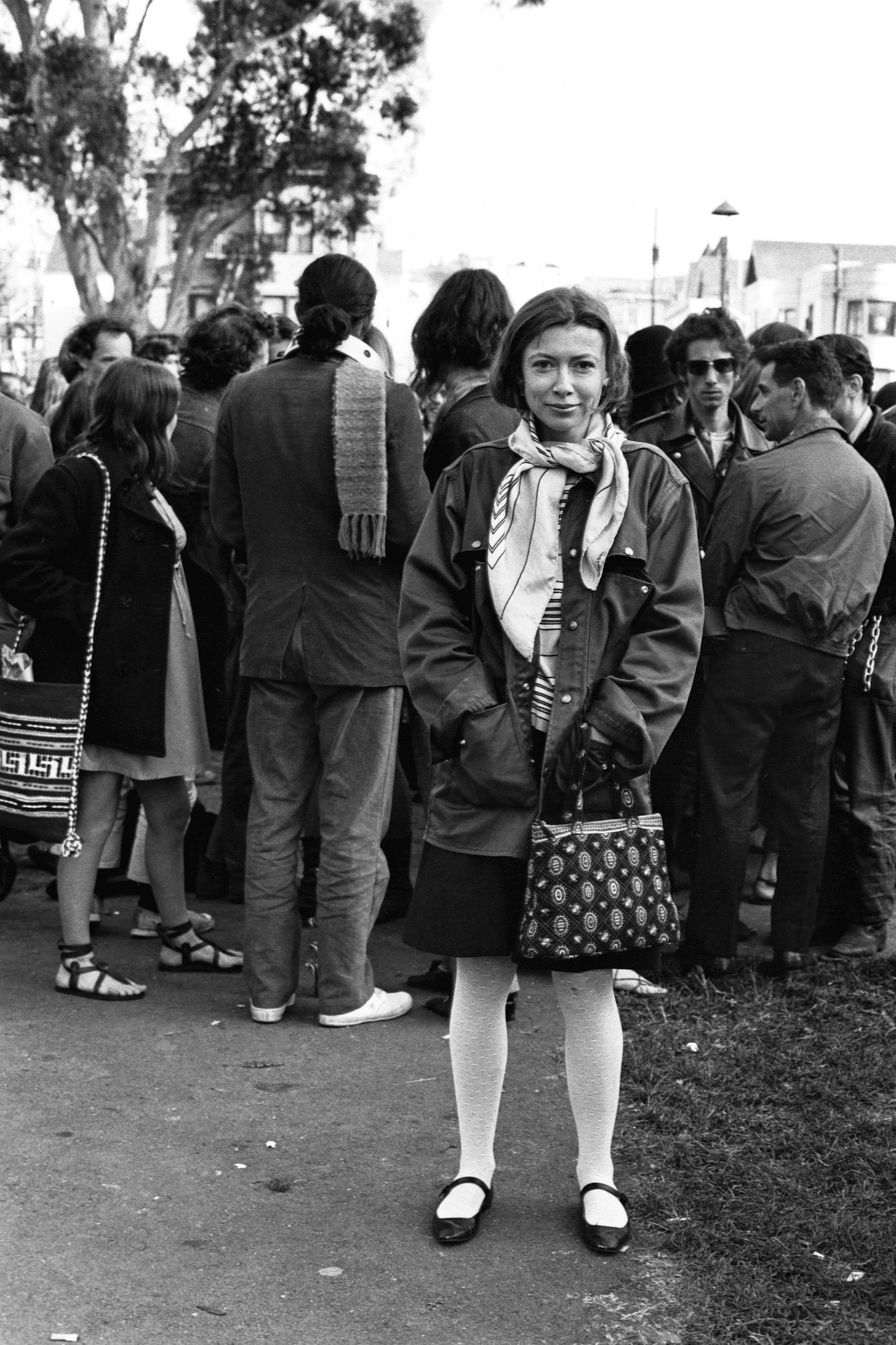 Η συγγραφέας Joan Didion στέκεται στο πάρκο Golden Gate Park με μια ομάδα χίπηδων κατά τη διάρκεια της συγγραφής του άρθρου της «Slouching Towards Bethlehem»