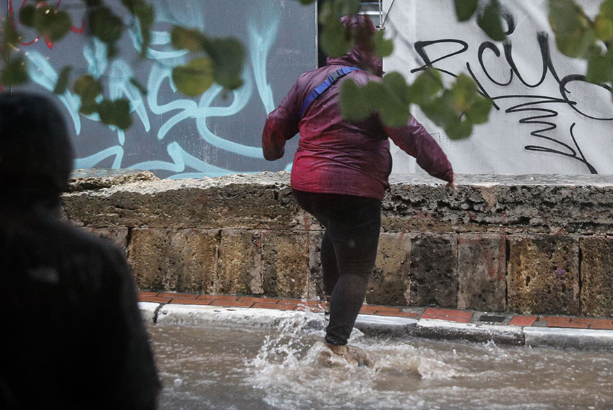Κακοκαιρία: Πεζός διασχίζει πλημμυρισμένο δρόμο στο κέντρο της Αθήνας