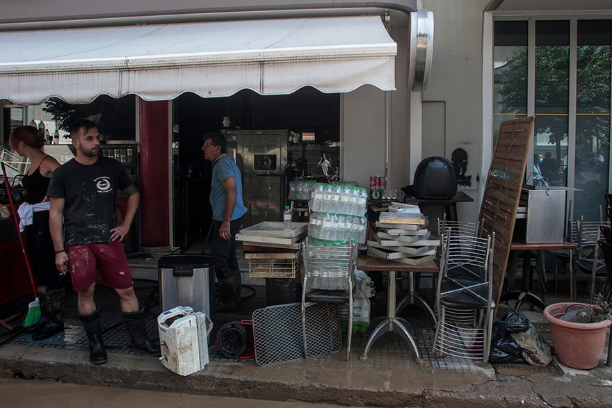 Κάτοικοι στην Καρδίτσα στοιβάζουν αντικείμενα έξω από κατάστημα, συνεχίζοντας τους καθαρισμούς μετά την κακοκαιρία που προκάλεσε μεγάλες πλημμύρες στην πόλη