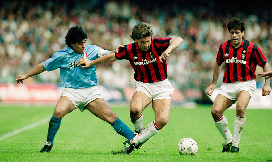 Ο Μαραντόνα, με τη φανέλα της Νάπολι, κόντρα στον Κάρλο Αντσελότι της Μίλαν για το πρωτάθλημα Ιταλίας (21 Οκτωβρίου 1990) - Ο Αργεντινός ποδοσφαιριστής οδήγησε την ιταλική ομάδα του Νότου στην κορυφή του πρωταθλήματος και λατρεύτηκε σαν... Θεός