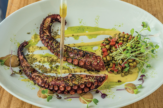 Χταπόδι σχάρας πάνω σε κρέμα φάβας Σαντορίνης, ροβίτσα μαριναρισμένη με κυκλαδίτικα μυρωδικά και βινεγκρέτ από τους χυμούς του χταποδιού με πετιμέζι και λαδόξυξο. 