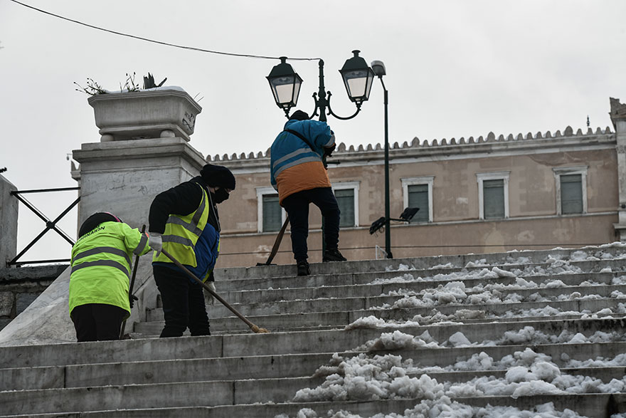 Υπάλληλοι του Δήμου Αθηναίων καθαρίζουν την πλατεία Συντάγματος από τα χιόνια