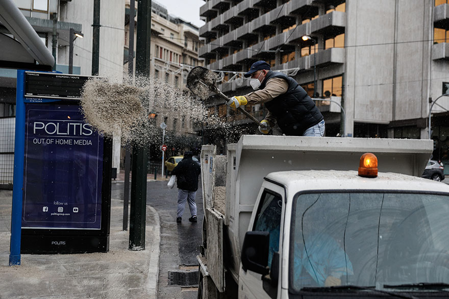 Στο Σύνταγμα υπάλληλος του Δήμου Αθηναίων ρίχνει αλάτι για τον πάγο, καθώς η κακοκαιρία «Ελπίς» έφερε χιόνια στο κέντρο της Αθήνας